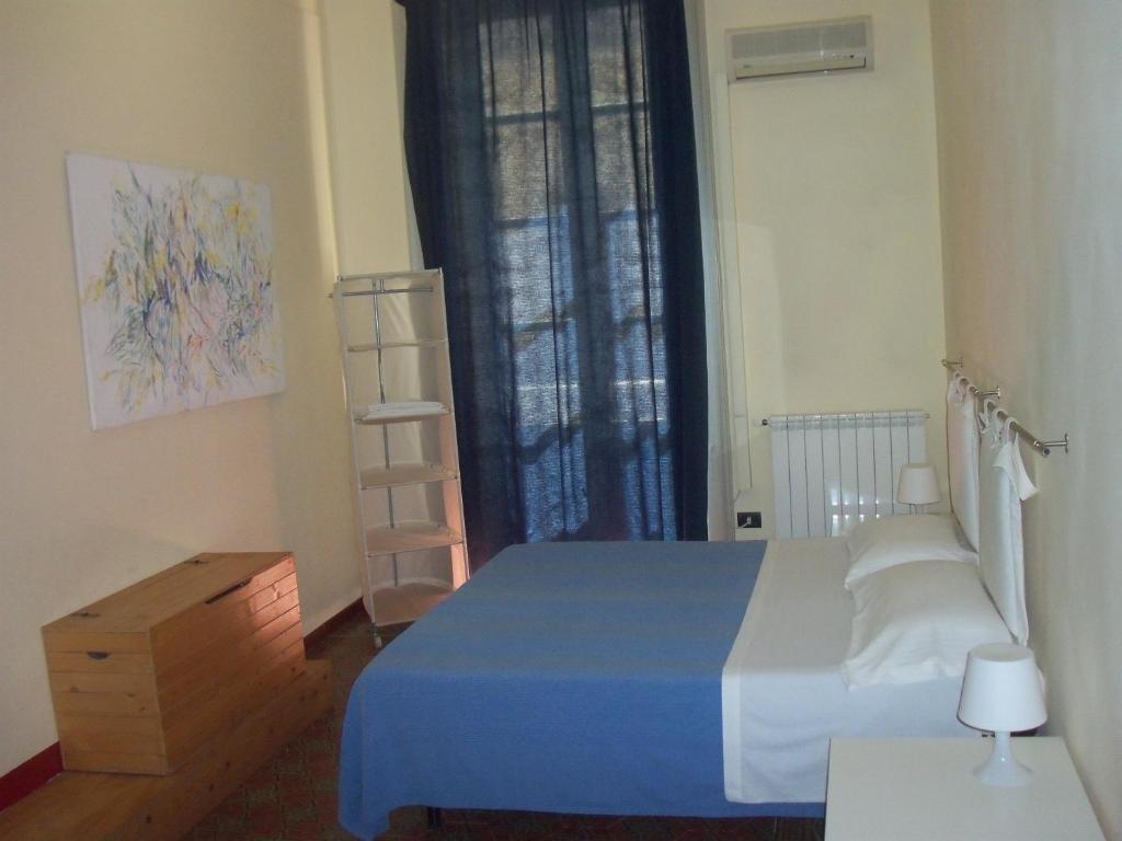 锡拉库扎B&B CARAVAGGIO SIRACUSA basic rooms with bathroom 200 Metres from Ortigia的一间卧室设有蓝色的床和窗户。