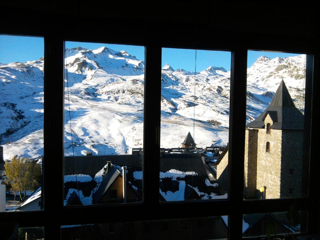 福米加尔Ski & relax Apartment的从窗户可欣赏到白雪 ⁇ 的山景