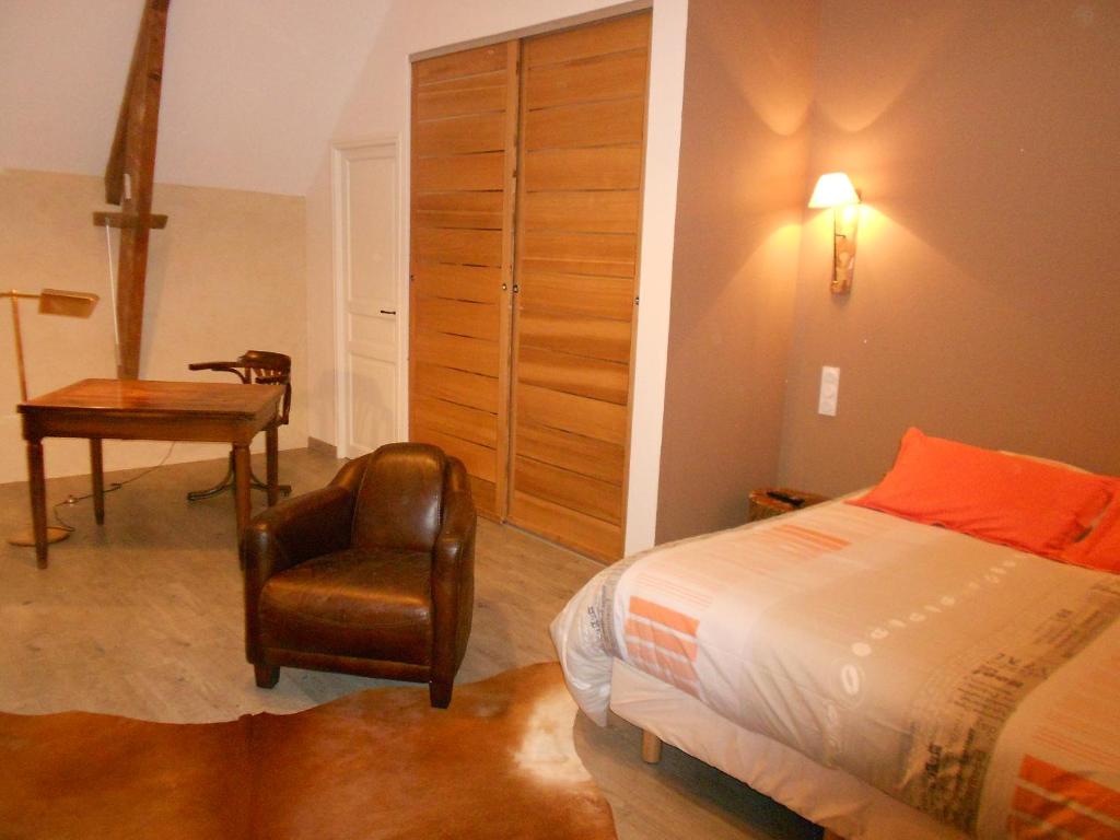La CambeFerme de Savigny的一间卧室配有一张床、一把椅子和一张书桌
