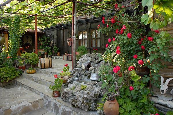 泽拉夫纳Guest House Polah Ot Minaloto的温室里种有玫瑰和石头瀑布的花园