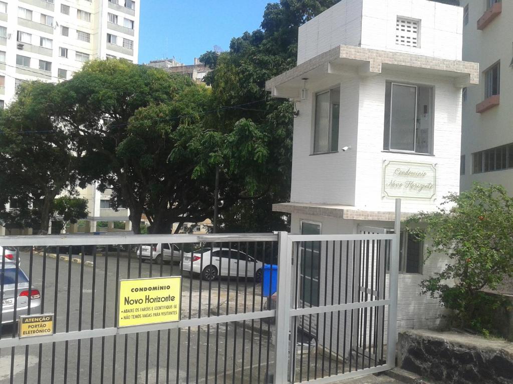 萨尔瓦多Apartamento en Salvador bahía com ar condicionado的建筑前的白色栅栏,上面有标志