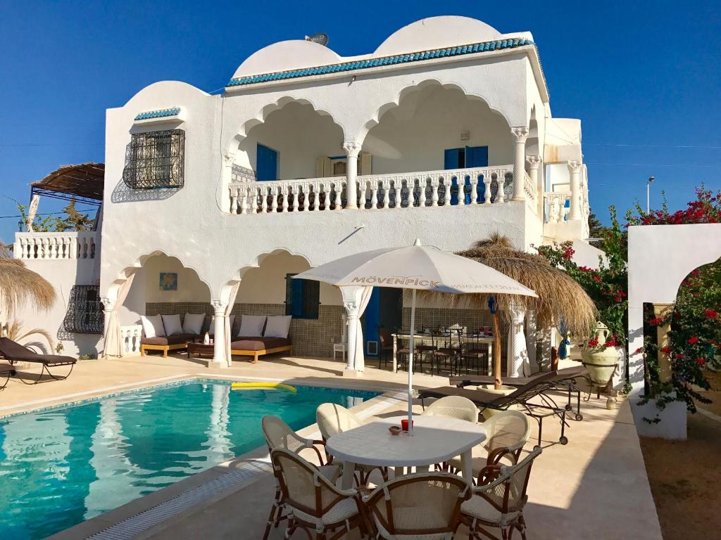 阿格希尔Menzel Churasco Djerba的别墅 - 带游泳池和桌椅