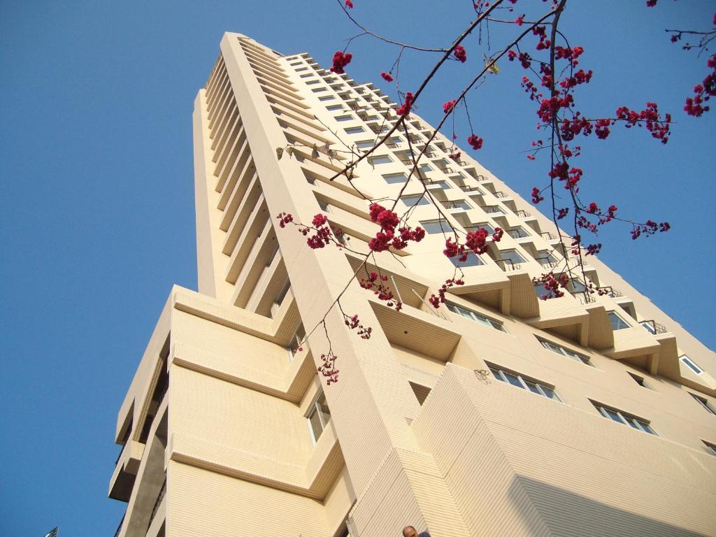 鱼池乡台湾真美日月潭会馆的一座高大的白色建筑,前面有红花