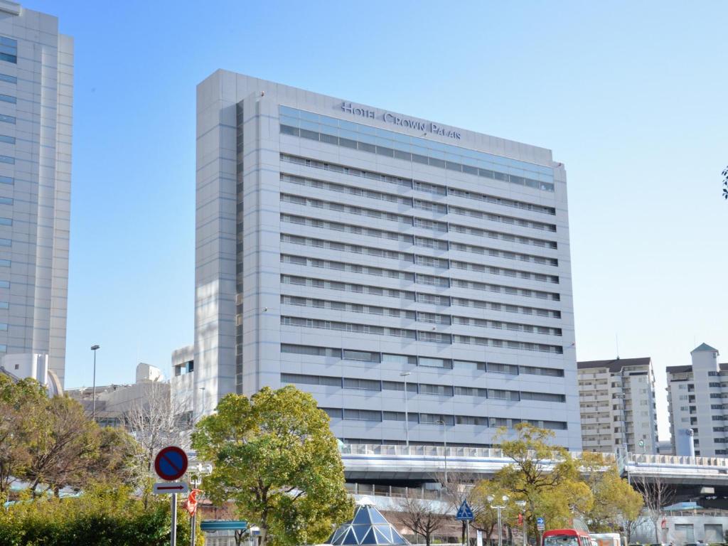 神户神户皇冠饭店的一座高大的白色建筑,上面有标志