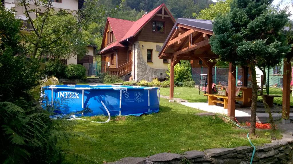 什切尔克Domek w Szczyrku的庭院内带热水浴池的房子