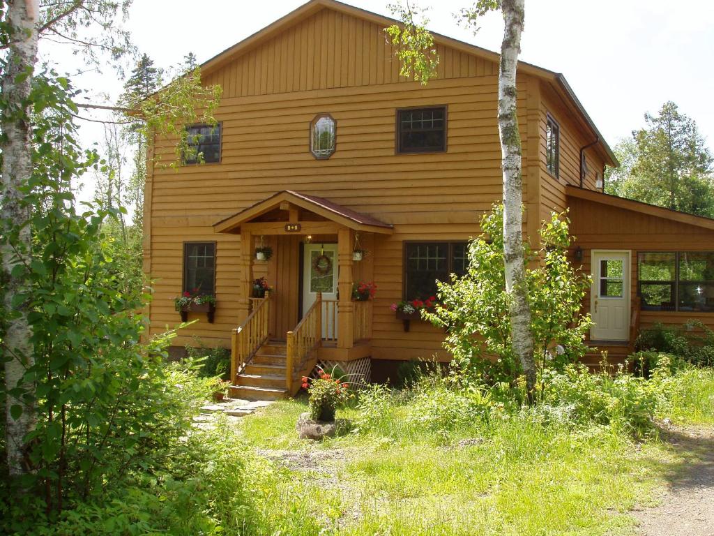 大急流城Poplar Creek Guesthouse的一个带门廊和门的原木房子