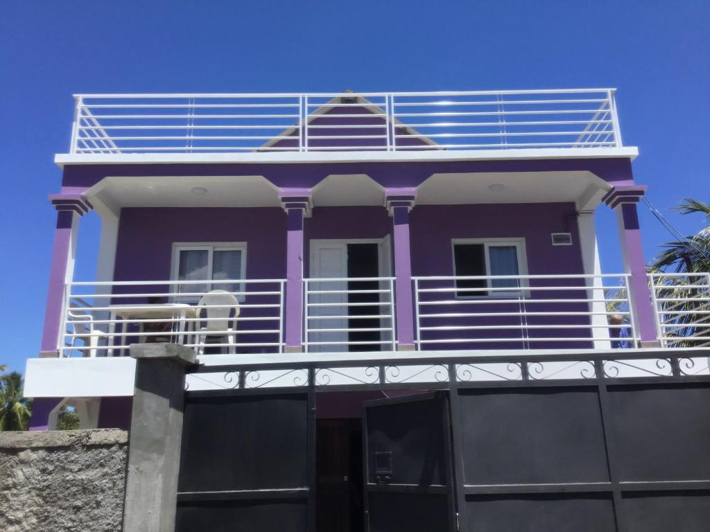 阿姆巴托洛阿卡Villa Violette的紫色房子的顶部设有阳台