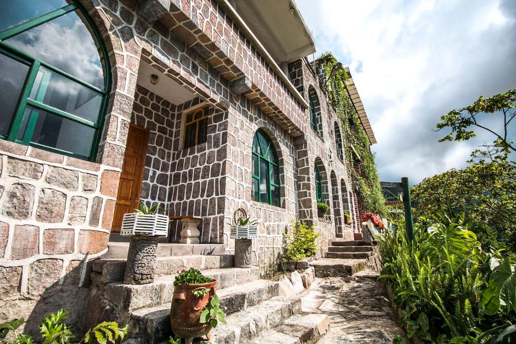 圣胡安拉拉古纳尤科斯拉布里阿提兰环保酒店的前面有楼梯的石头建筑