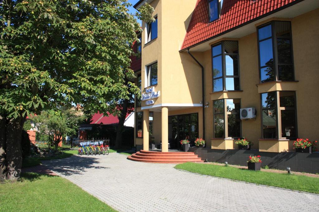 列斯诺伊瓦尔德公园酒店的一座有树和砖砌走道的建筑