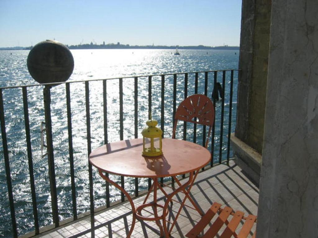 穆拉诺卡萨苏拉拉古纳旅馆的俯瞰水面的阳台配有桌椅