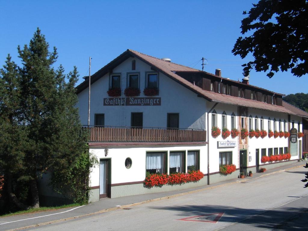 Schöfweg兰辛格尔全景酒店的一座白色的建筑,上面有读县锚的标志