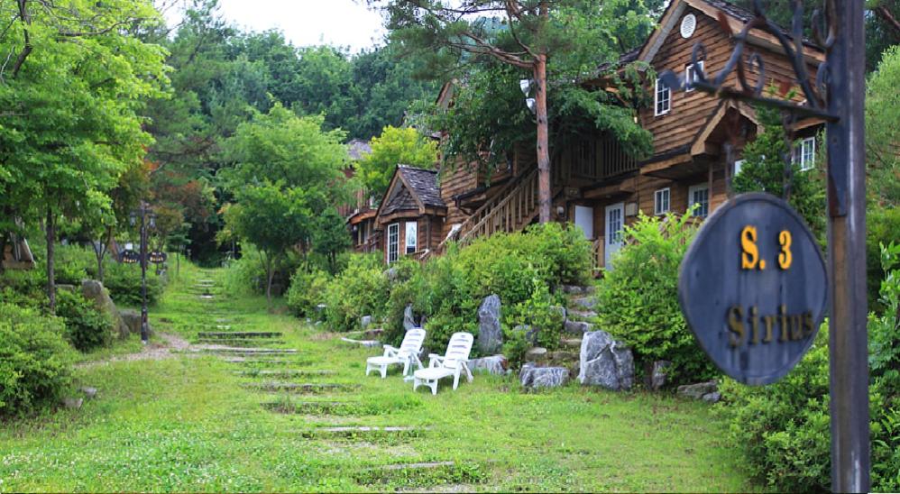 平昌梅费尔天津四旅馆的院子里有两把椅子和标志的房子