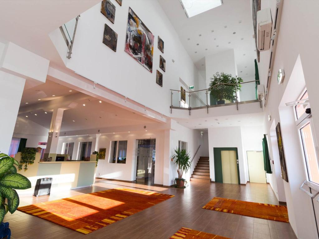 维也纳新城Winrooms Seminar Hotel & Apartments的大房间,地板上有一个大地毯