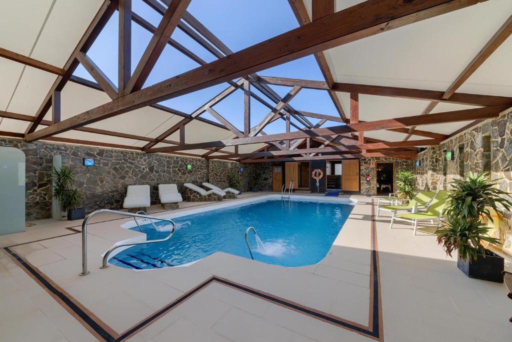 科尼尔-德拉弗龙特拉El Caseron de Conil & Spa的一座带天花板的建筑中的游泳池