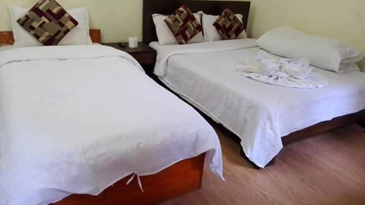 加德满都Hotel Sisters Home的配有白色床单的客房内的两张床