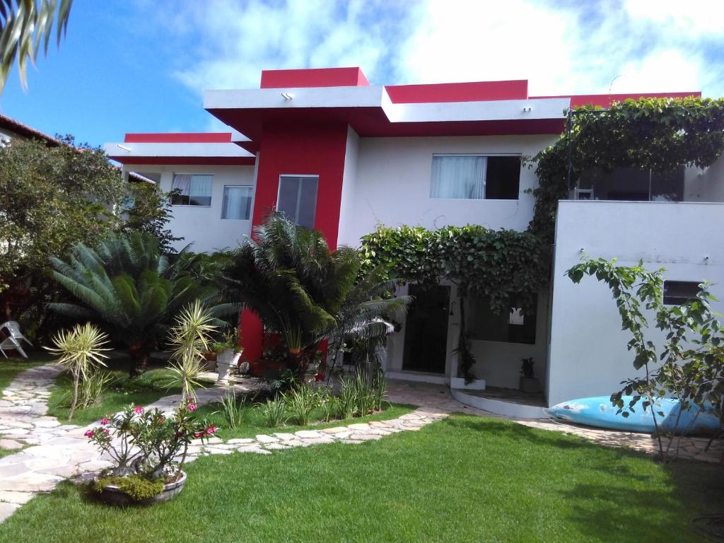 塞古罗港Casa Frente Praia do mutá Porto Seguro的一座红色和白色的房子,有院子