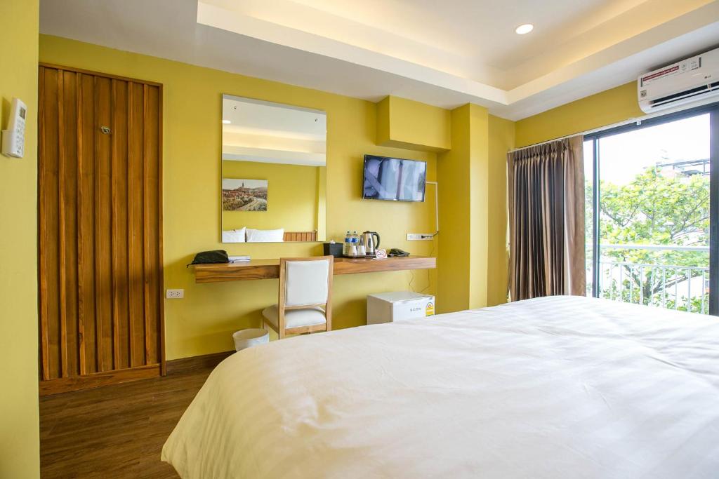 合艾禅南公寓公寓式酒店的一间卧室配有一张床和一张桌子及椅子