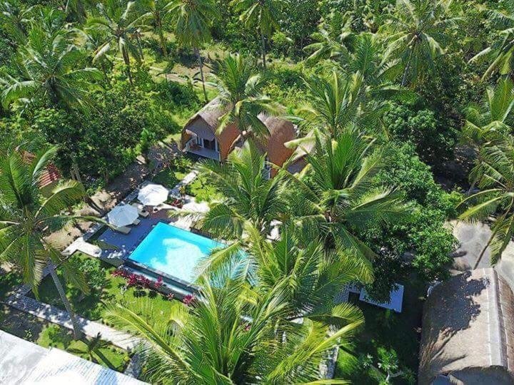 珀尼达岛宾塔格度假酒店的享有带游泳池和棕榈树的度假村的顶部景致