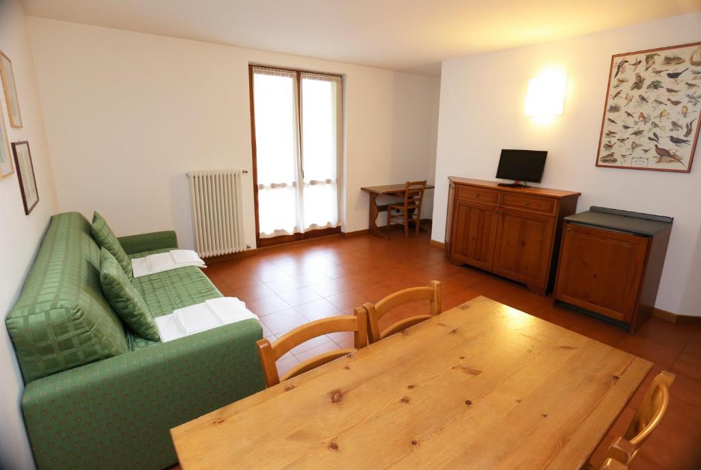 马代西莫Residence Primula的客厅配有绿色沙发和木桌
