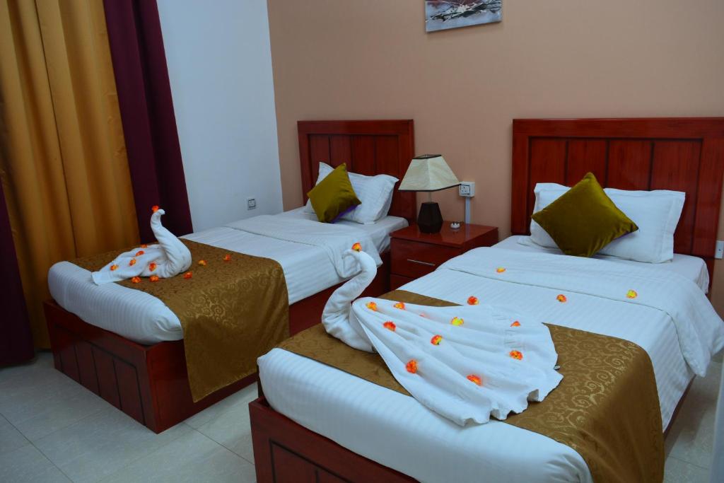 尼兹瓦奥卡拉姆酒店的酒店客房带两张床,带装饰。