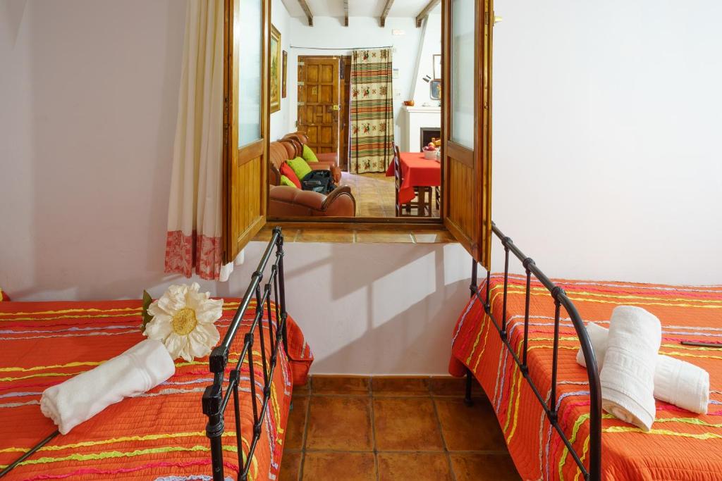 丰特-德彼德拉Alojamientos rurales La Torca的一间卧室配有两张床和镜子