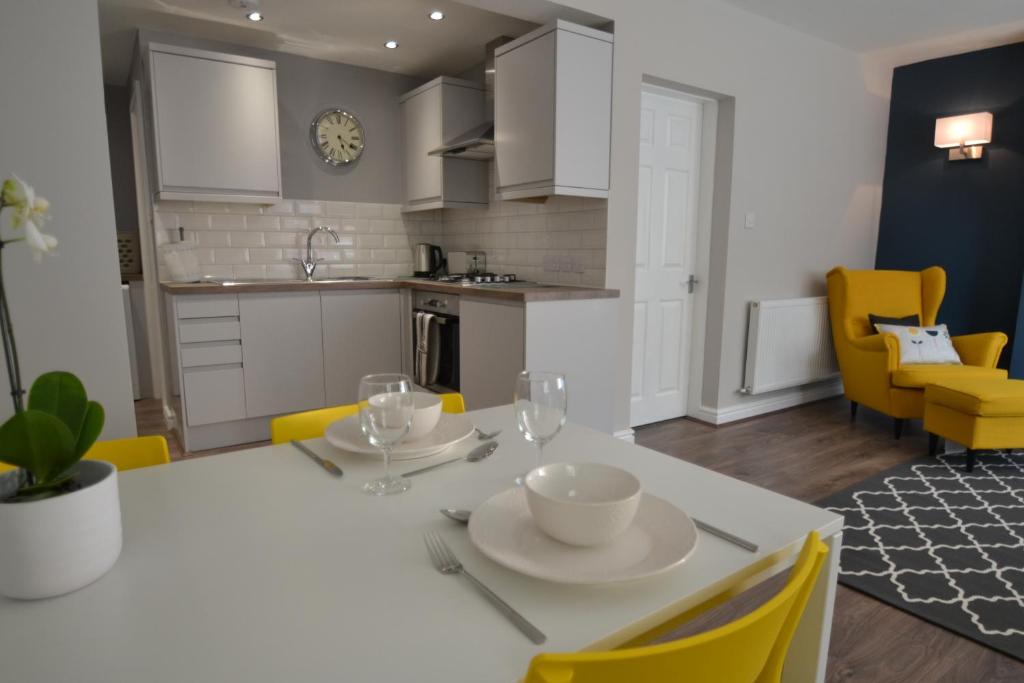 切斯特Charming 1 bed riverside apartment的厨房以及带白色桌子和黄色椅子的用餐室。