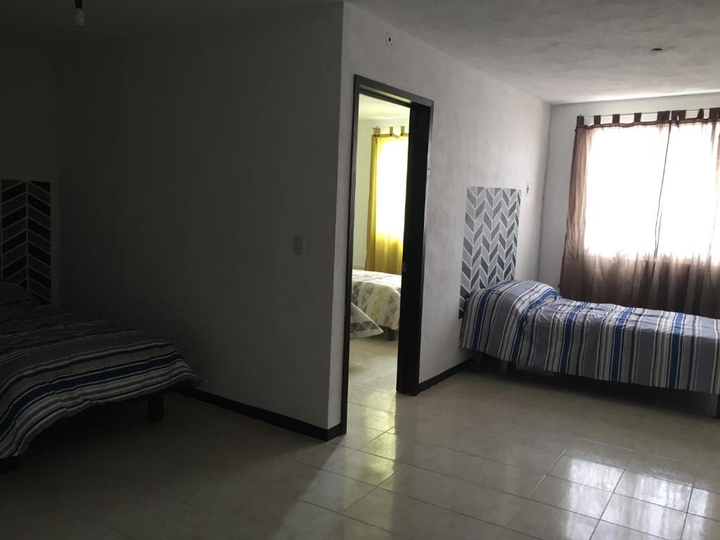 SanctórumHotelito Ejido的一间卧室设有一张床、一个窗口和一面镜子
