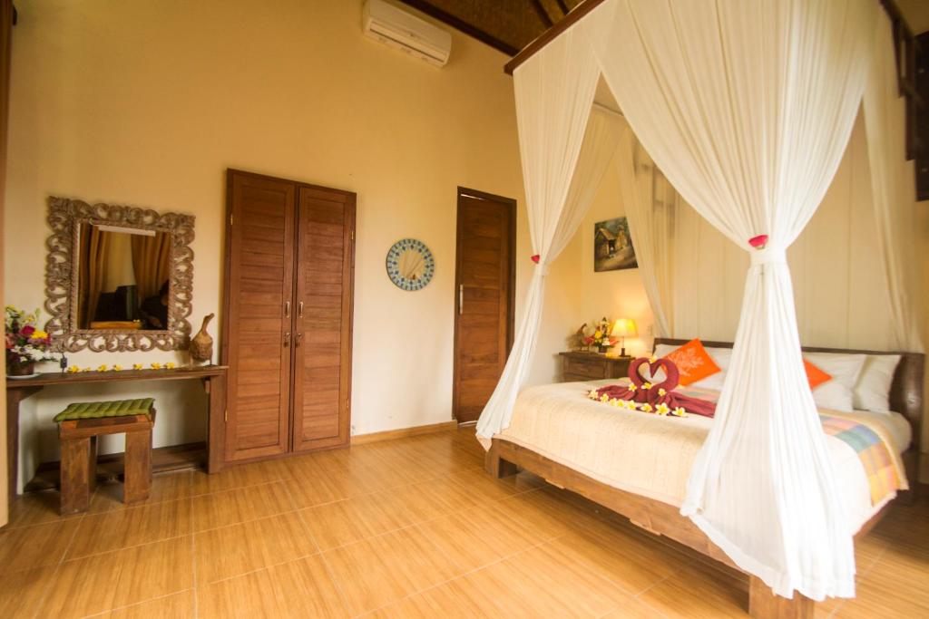 乌布Villa Ulun Mertha - 1BR Private Villa的一间卧室配有一张带蚊帐的床