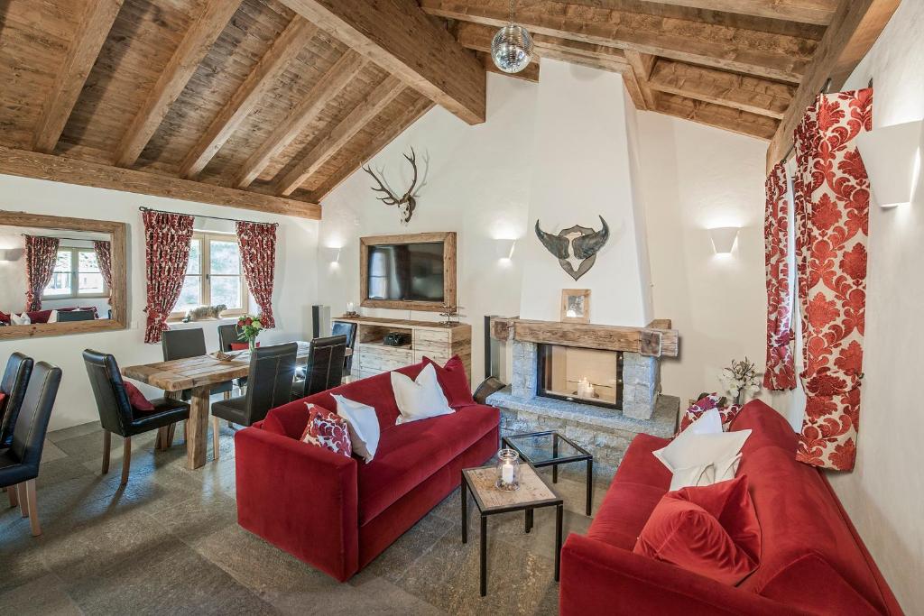 切勒里纳霍特力诺佩蒂特小木屋旅馆的客厅配有红色家具和壁炉
