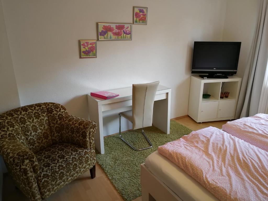 科隆科隆公寓酒店的一间卧室配有书桌、椅子和电视。