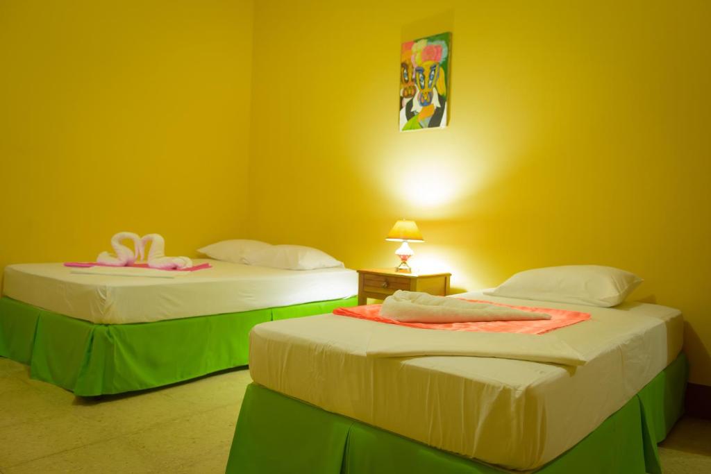 莱昂Hostal Fachente的黄色墙壁客房的两张床