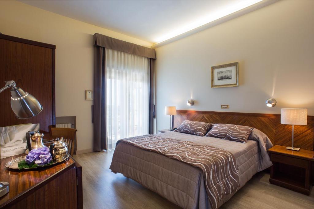 弗拉斯卡蒂卡夏尼酒店的一间卧室配有一张床和一张带台灯的桌子