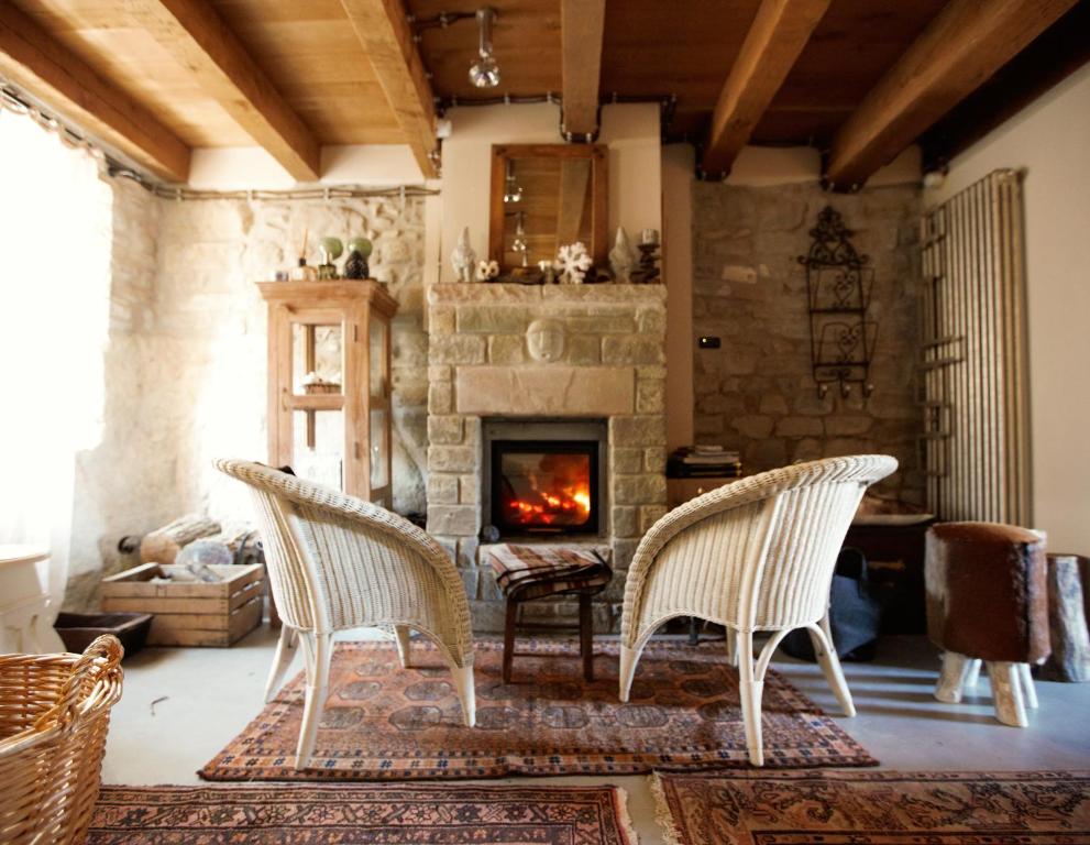 PolinagoCastello di Brandola的带壁炉的客厅配有两把椅子