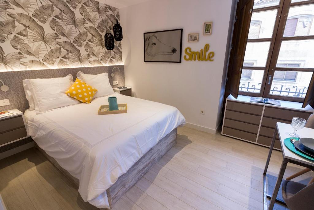 萨拉曼卡比萨拉曼卡公寓的小卧室配有一张挂着微笑标志的床铺