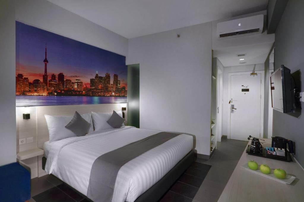 雅加达雅加达克巴约蓝尼奥酒店的卧室配有一张白色大床,墙上挂有绘画作品