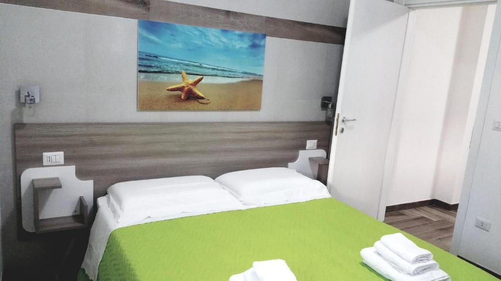 圣维托诺曼La Bella Vita的一间卧室配有一张带绘画的绿色和白色的床