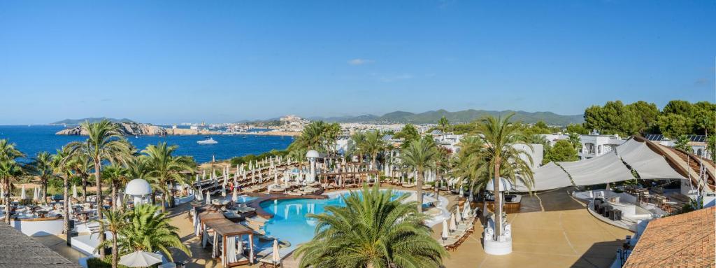塔拉曼卡Destino Pacha Ibiza的享有带游泳池和棕榈树的度假村的景致