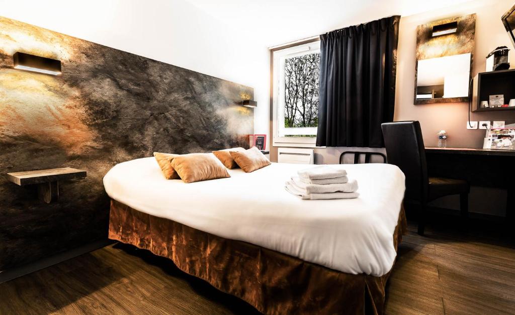 隆勒索涅隆勒索涅乐吉斯酒店 - 烧烤餐厅的一间卧室配有一张大床和毛巾