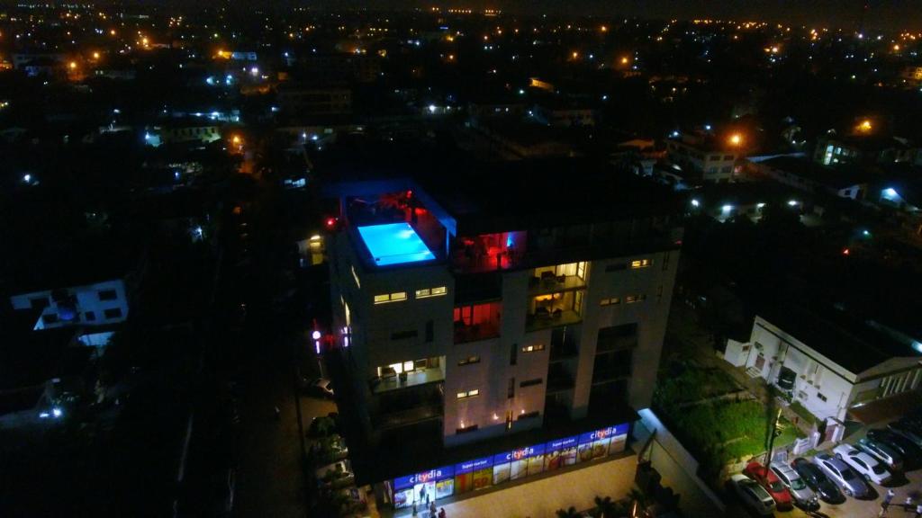 阿克拉Suncity Hotel Apartment的一座晚上有灯的建筑