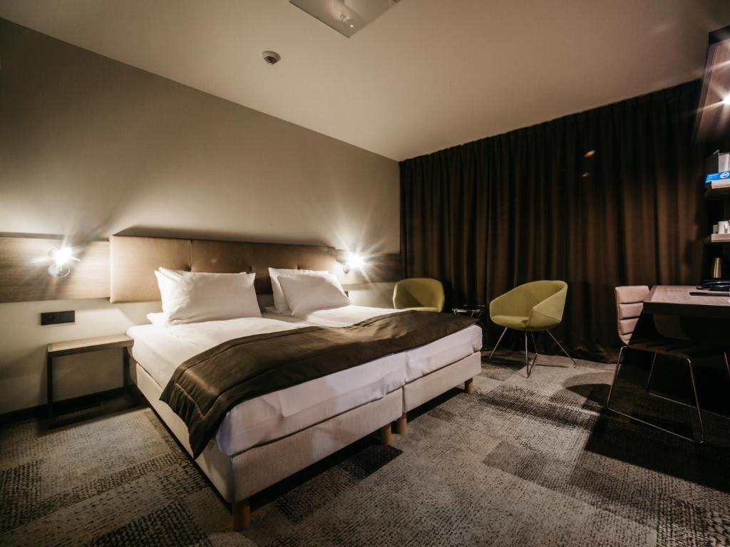 卡托维兹卡托维兹普乐斯Q酒店的配有一张床和一张书桌的酒店客房