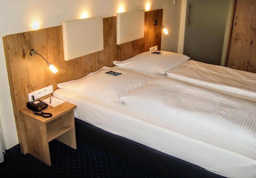慕尼黑丹尼尔酒店的一间卧室配有一张大床和木制床头板