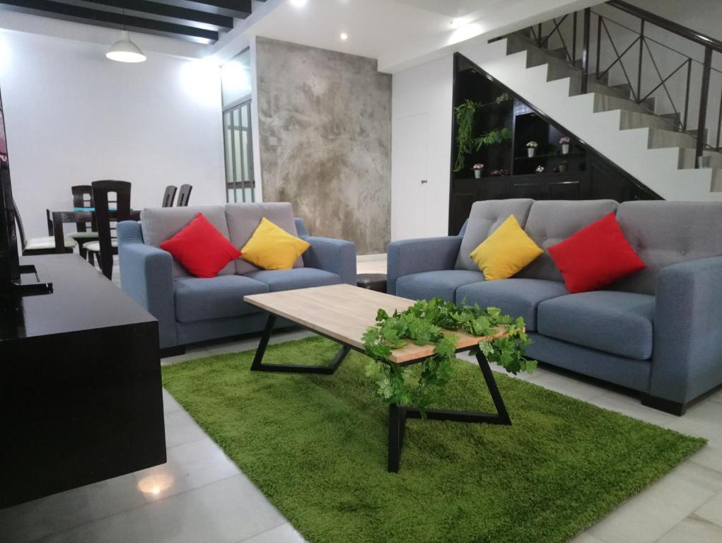 新山Escape to Bukit Indah Legoland Retreat Your 5BR Homestay for 1-16 Guests的客厅配有两张沙发和一张桌子