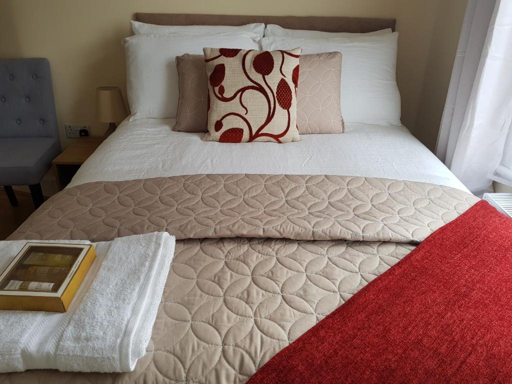 恩菲尔德卡瑟林优质公寓式酒店的一间卧室配有一张红色地毯的床