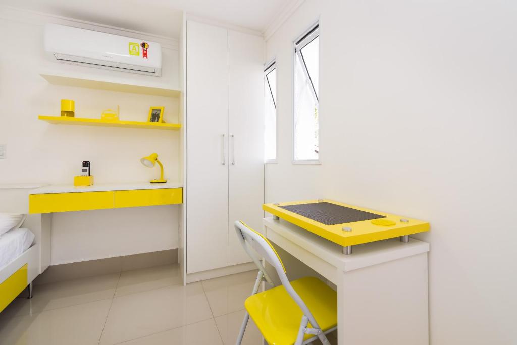 圣保罗Villa Sophia的一间小厨房,配有黄色的桌子和黄色的椅子