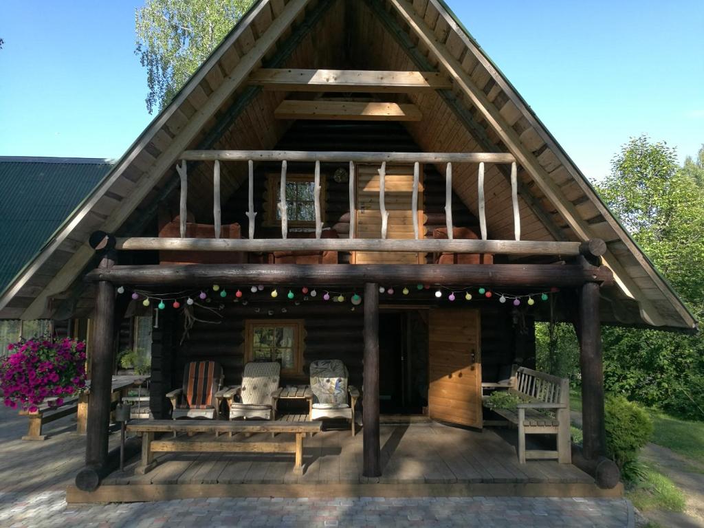 VecslavēkasGuest House Vējaines的大型小木屋,设有屋顶和门廊