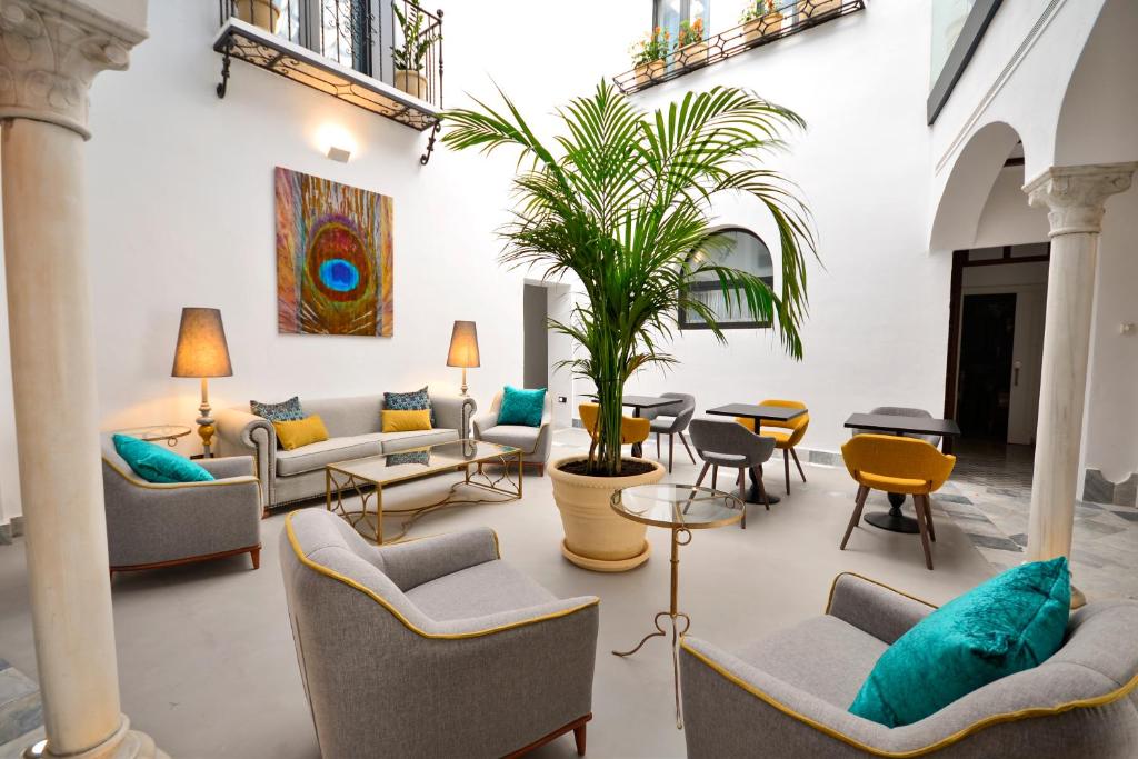 塞维利亚Hotel Legado Alcazar的带沙发和盆栽植物的客厅