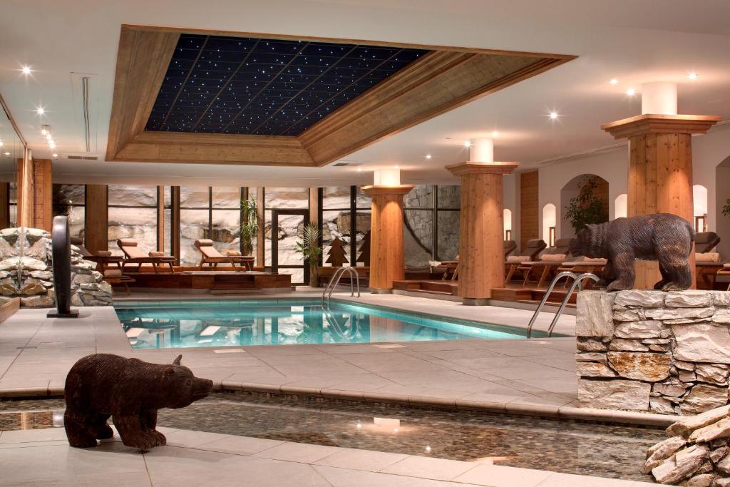 瓦勒迪泽尔雷巴赫默德鲁斯酒店的一座带熊雕像的游泳池的房子