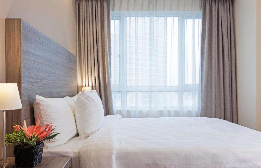 马尼拉One Pacific Place Serviced Residences的卧室配有白色的床和大窗户