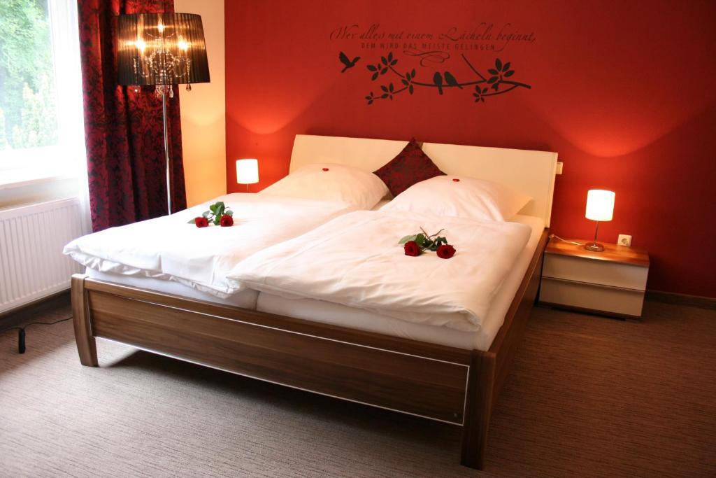 戈斯拉尔格罗尔酒店的一间卧室,床上放着两朵鲜花