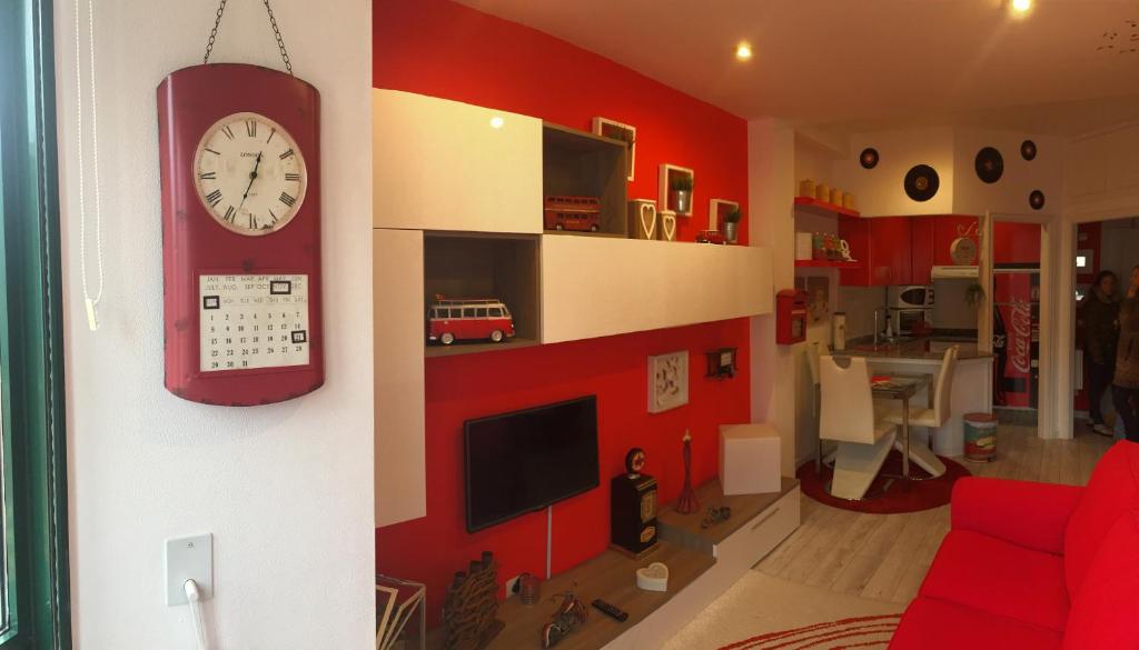 拉科鲁尼亚Apartamento En Pleno Centro的客厅设有红色的墙壁和时钟